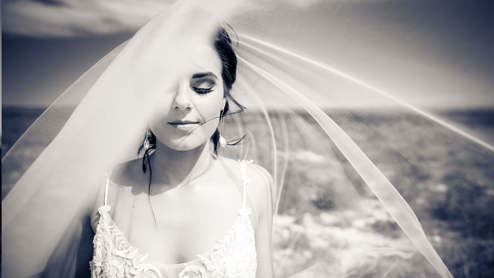 Contented bride with large wedding veil.